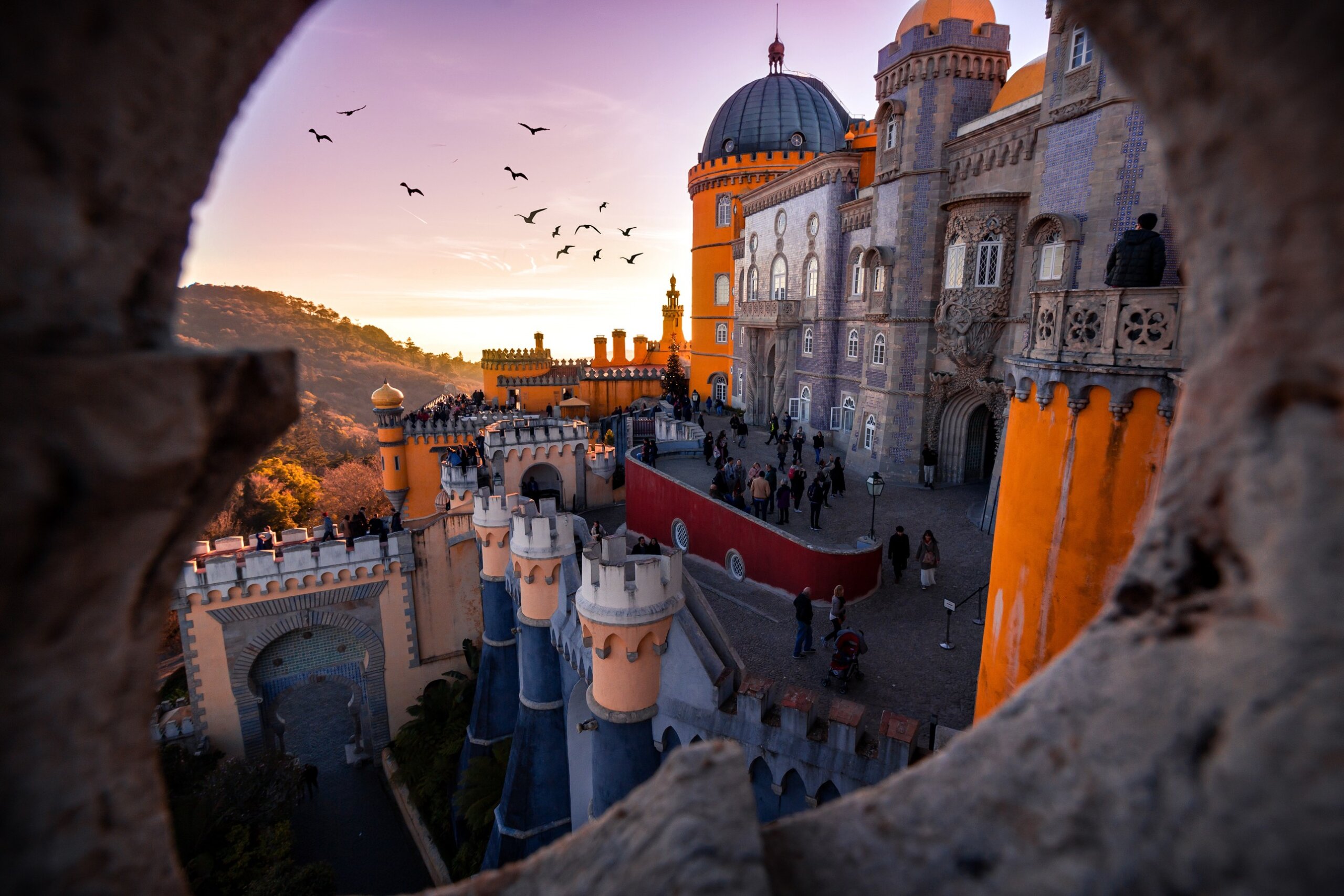 Pena Palace in Sintra Portugal at sunset with colorful towers and dramatic architecture