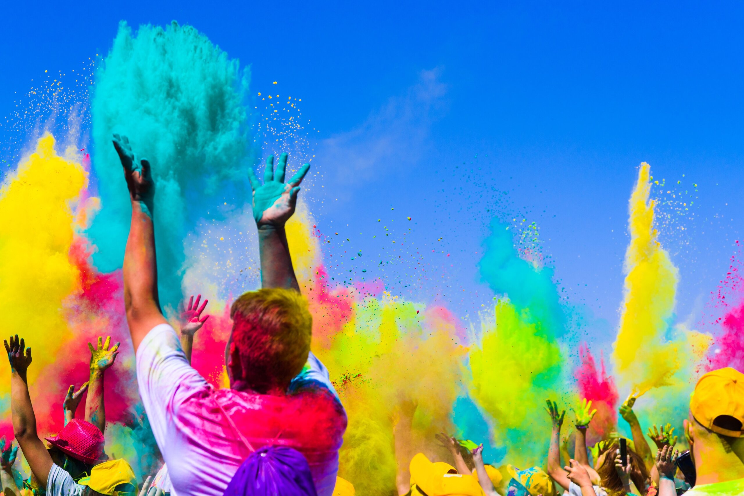 People celebrating Holi festival with colorful powder clouds during one of the world’s most vibrant holidays