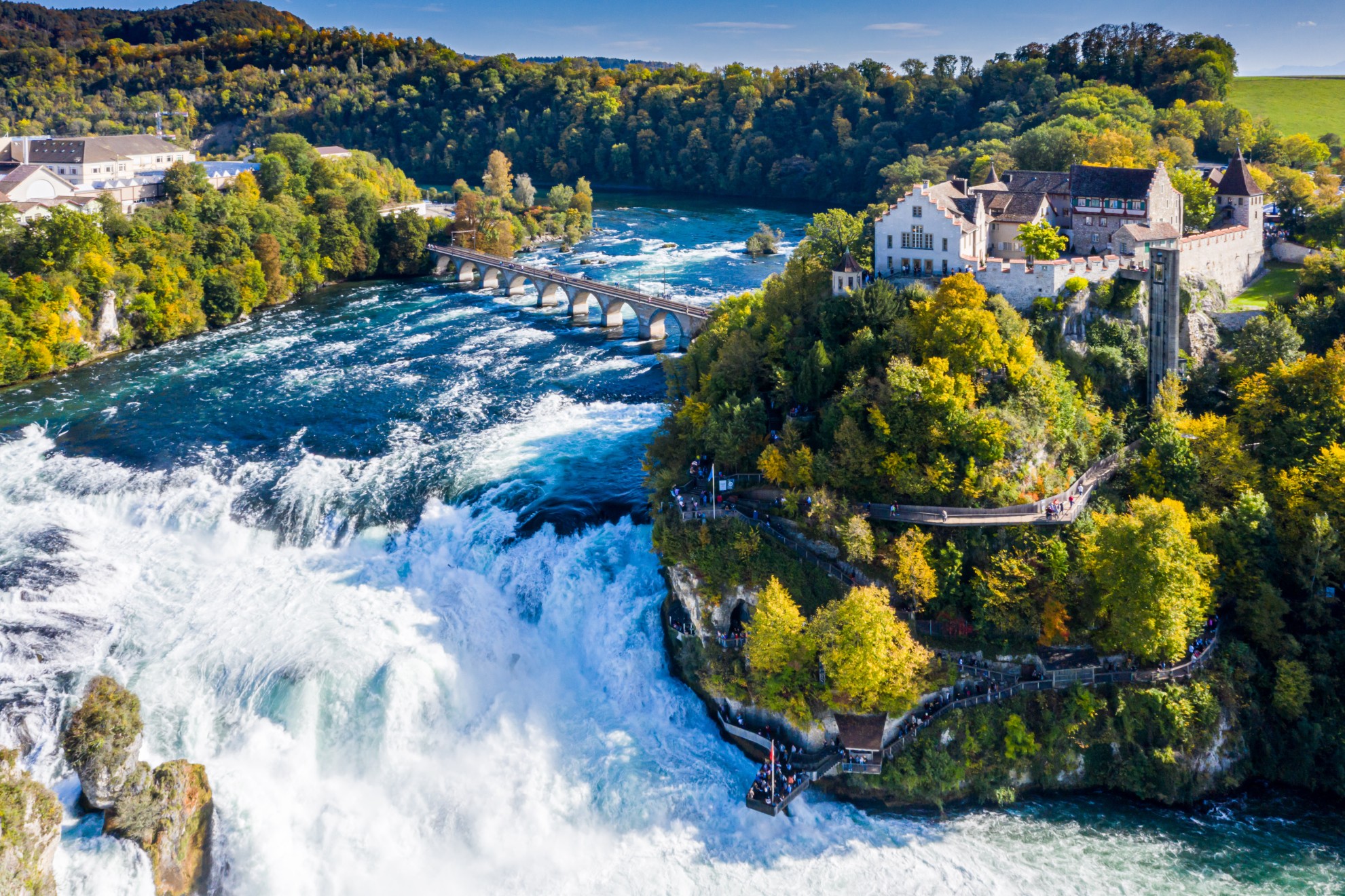 Rhine Falls or Rheinfall, Switzerland panoramic aerial view. Tourist boat in waterfall. Bridge and border between the cantons Schaffhausen and Zurich. Cliff-top Schloss Laufen castle, Laufen-Uhwiesen