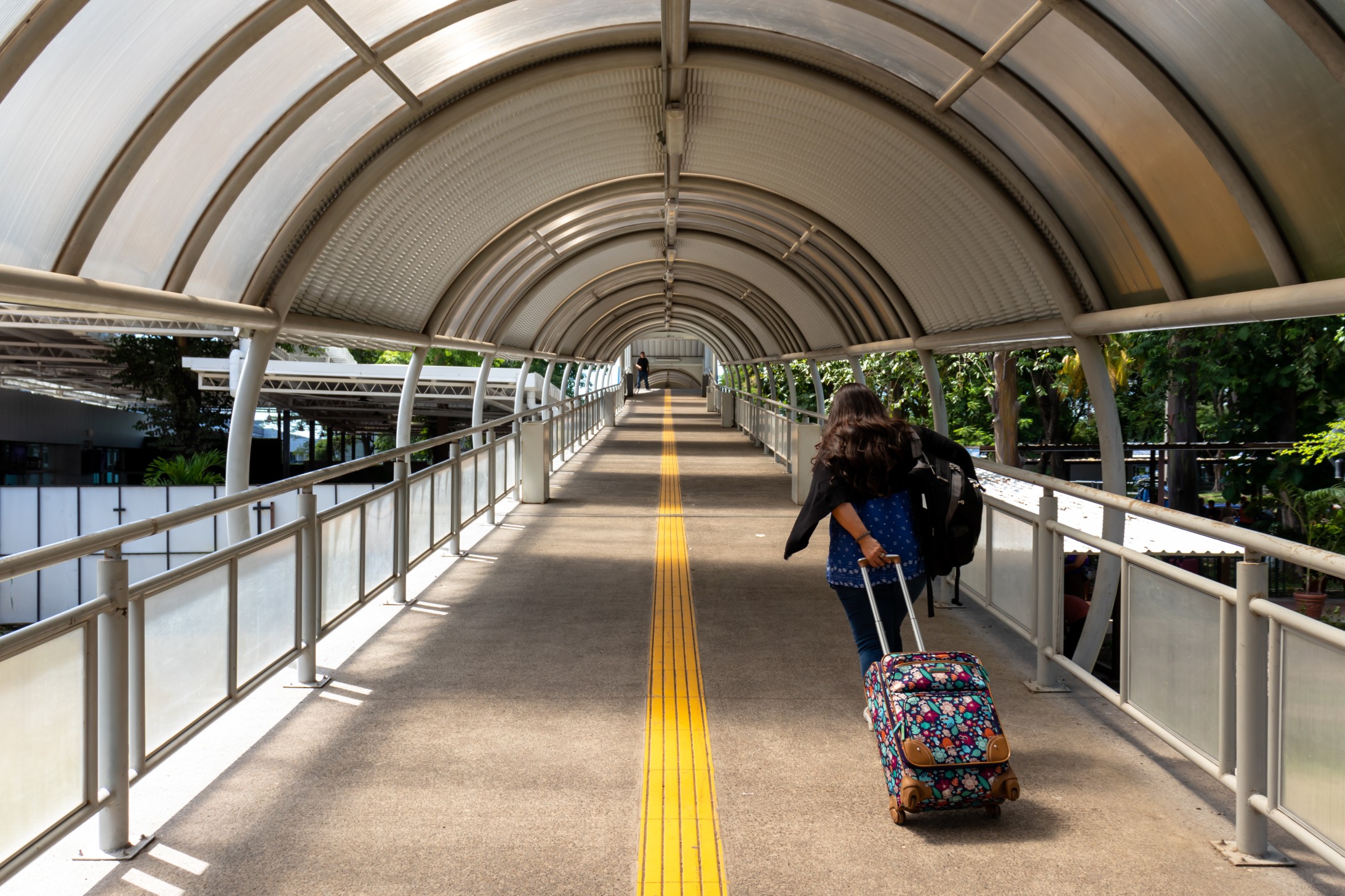 El Salvador, 11/01/2019.Lady pulling suitcase at the airport. Woman traveler. Travel concept. Arriving on time. Running late.
