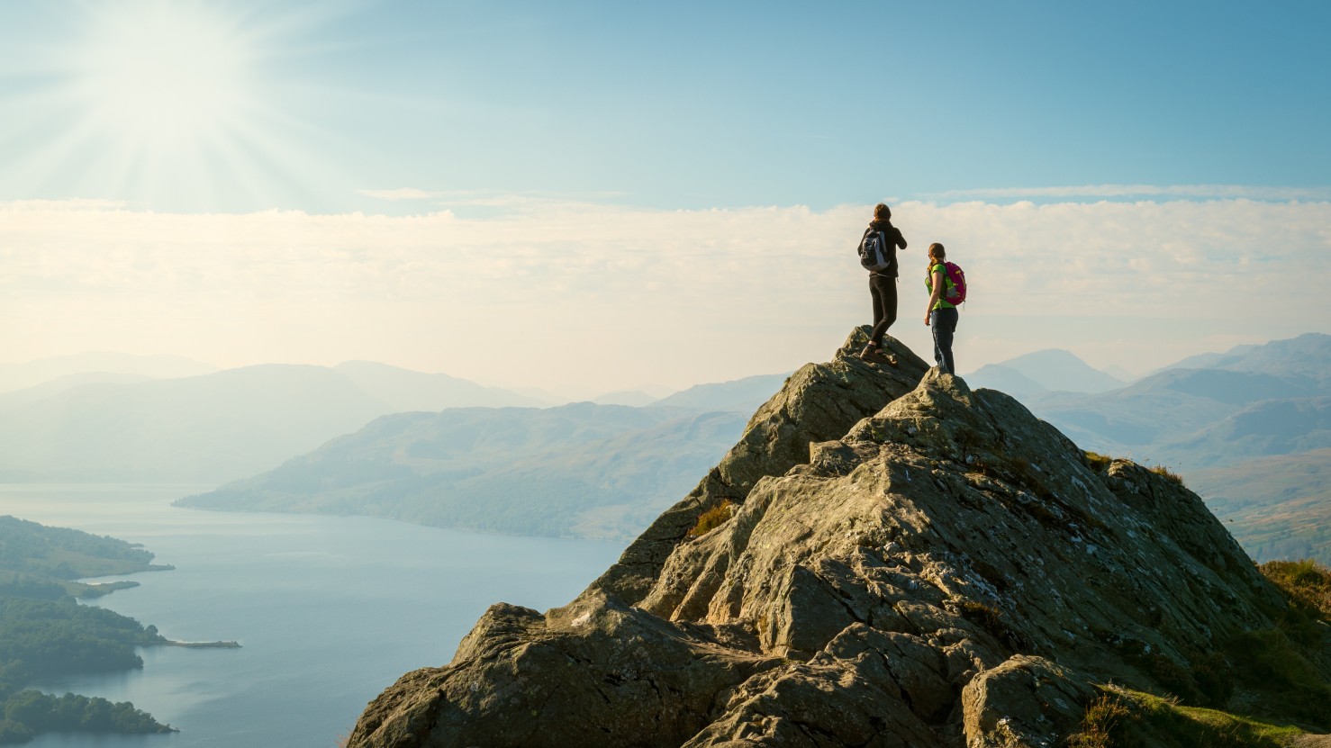 hikers on top of the mountain enjoying view, Highlands, Scotland
