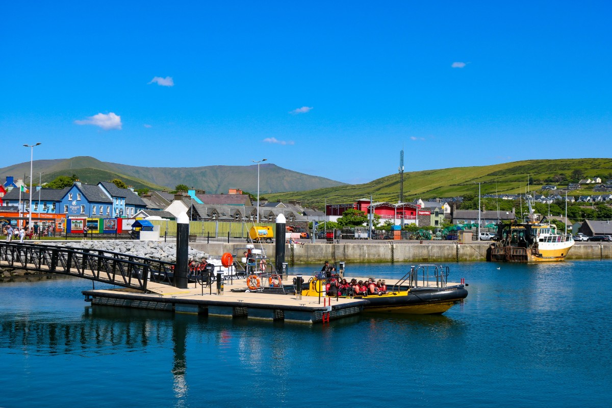 Dingle Harbor in Ireland with fishing boats colorful waterfront buildings and green hills