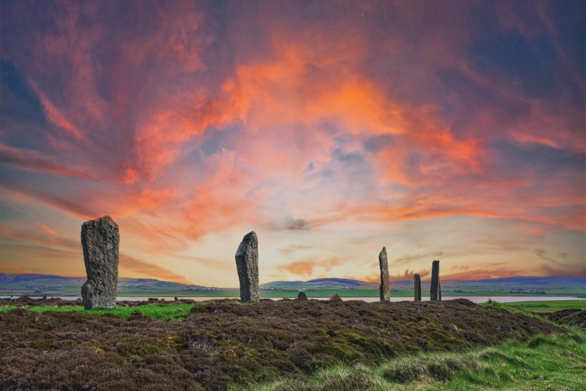 Ancient standing stones at sunset in the Orkney Islands Scotland with colorful skies and coastal landscape