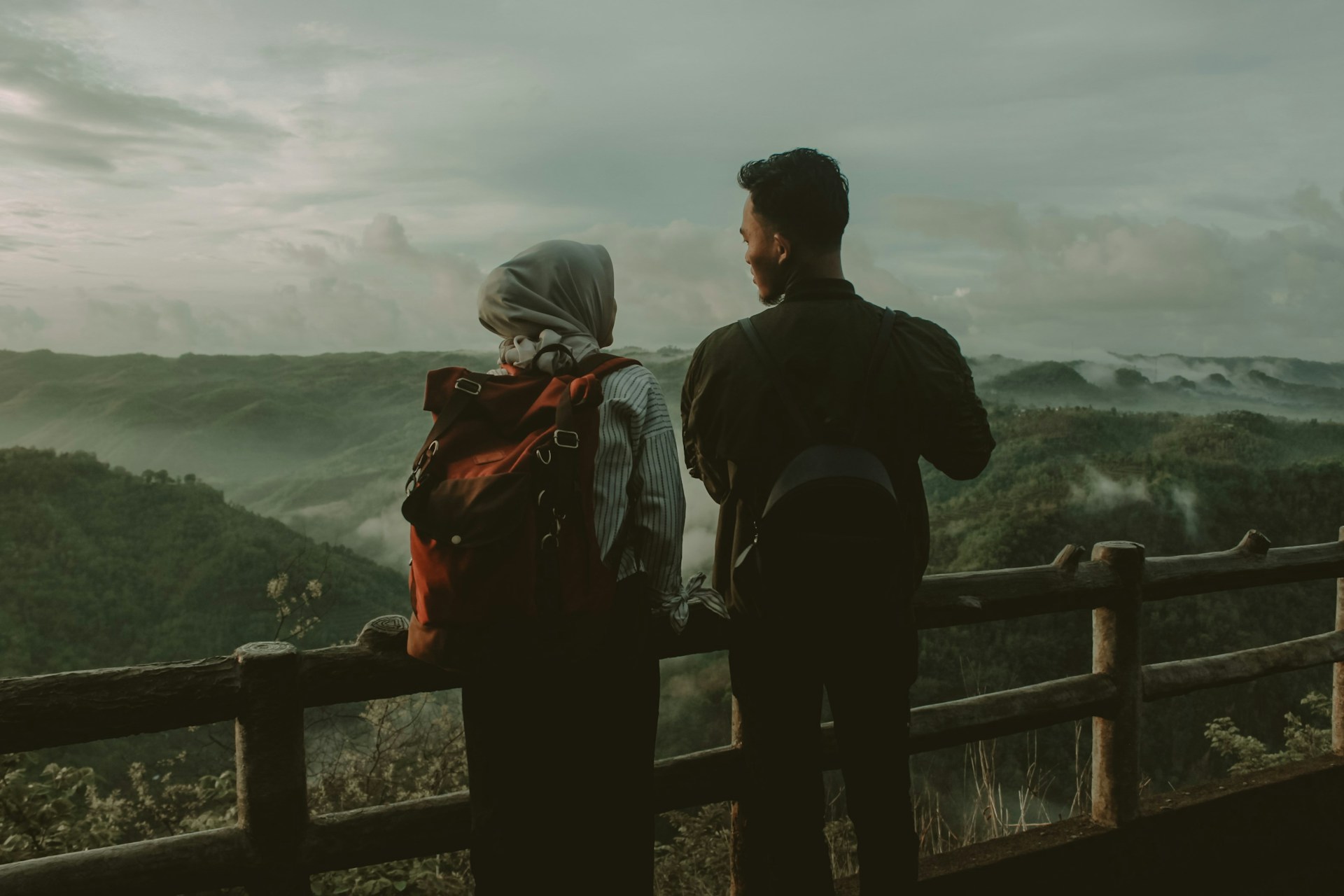 Two travel partners overlooking scenic mountain landscape during adventure trip