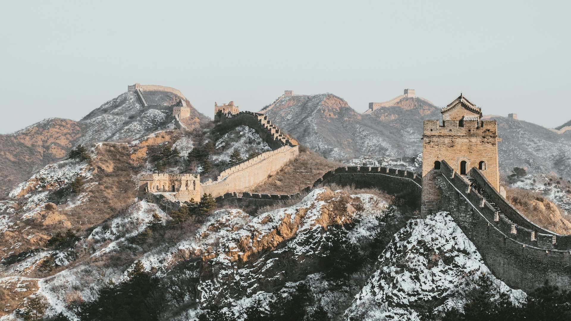 The Great Wall of China in winter for an article about tourist attractions with a dark history.