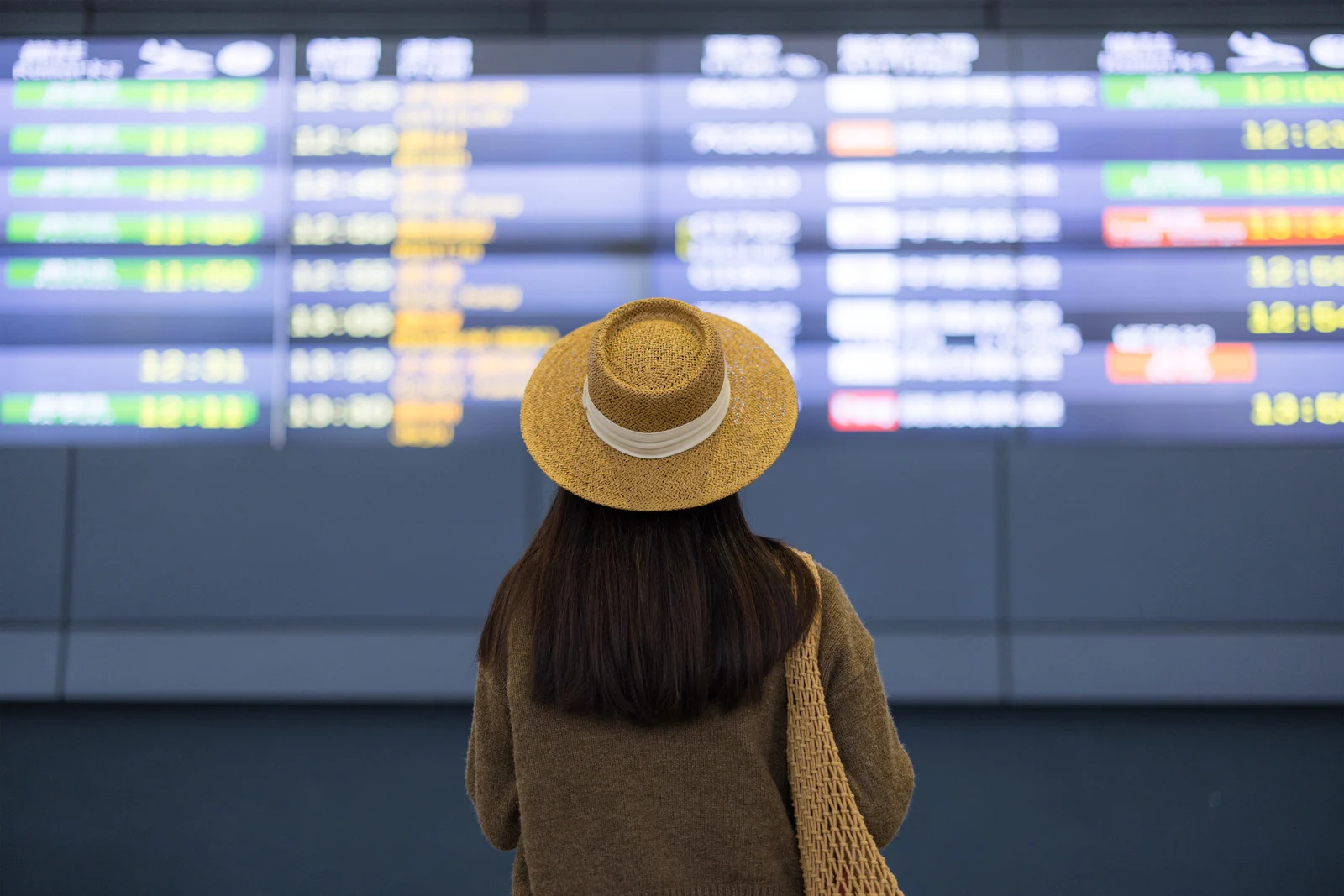 Traveler looking at airport departure board before domestic travel in the U.S.