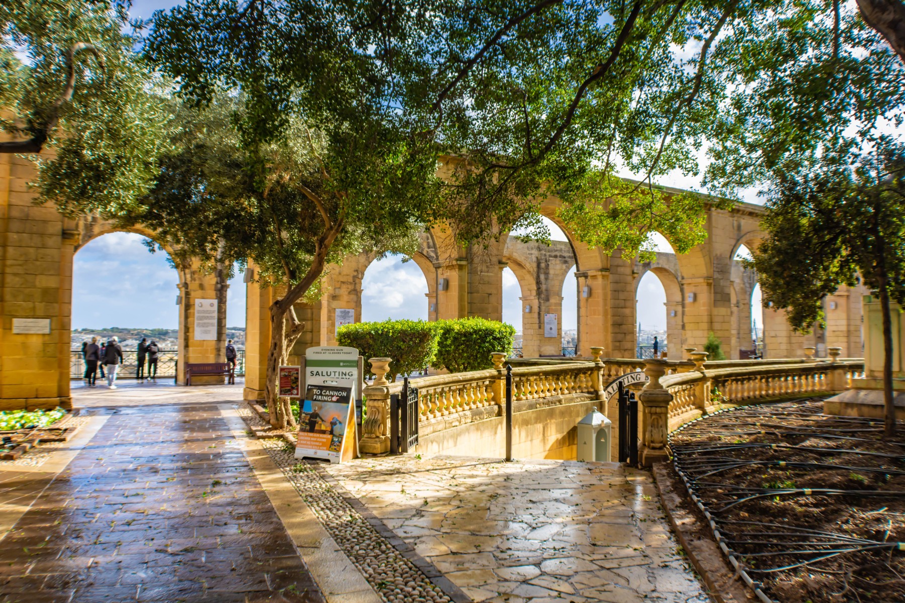 Colonnaded walkway under sunlight at the Upper Barrakka Gardens, Valletta, Malta
