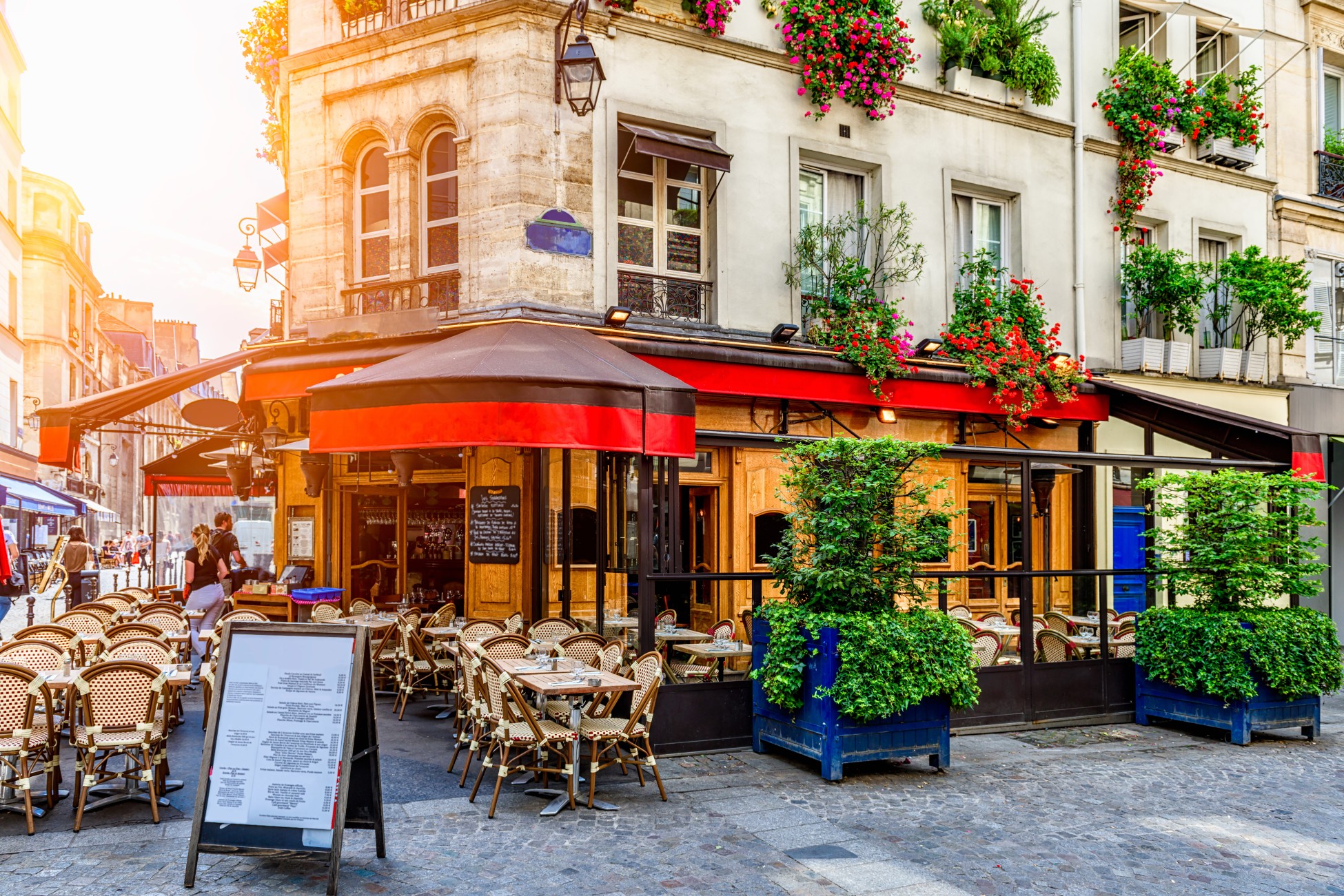 Cozy street with tables of cafe in Paris, France. Architecture and landmark of Paris. Cozy Paris cityscape.
