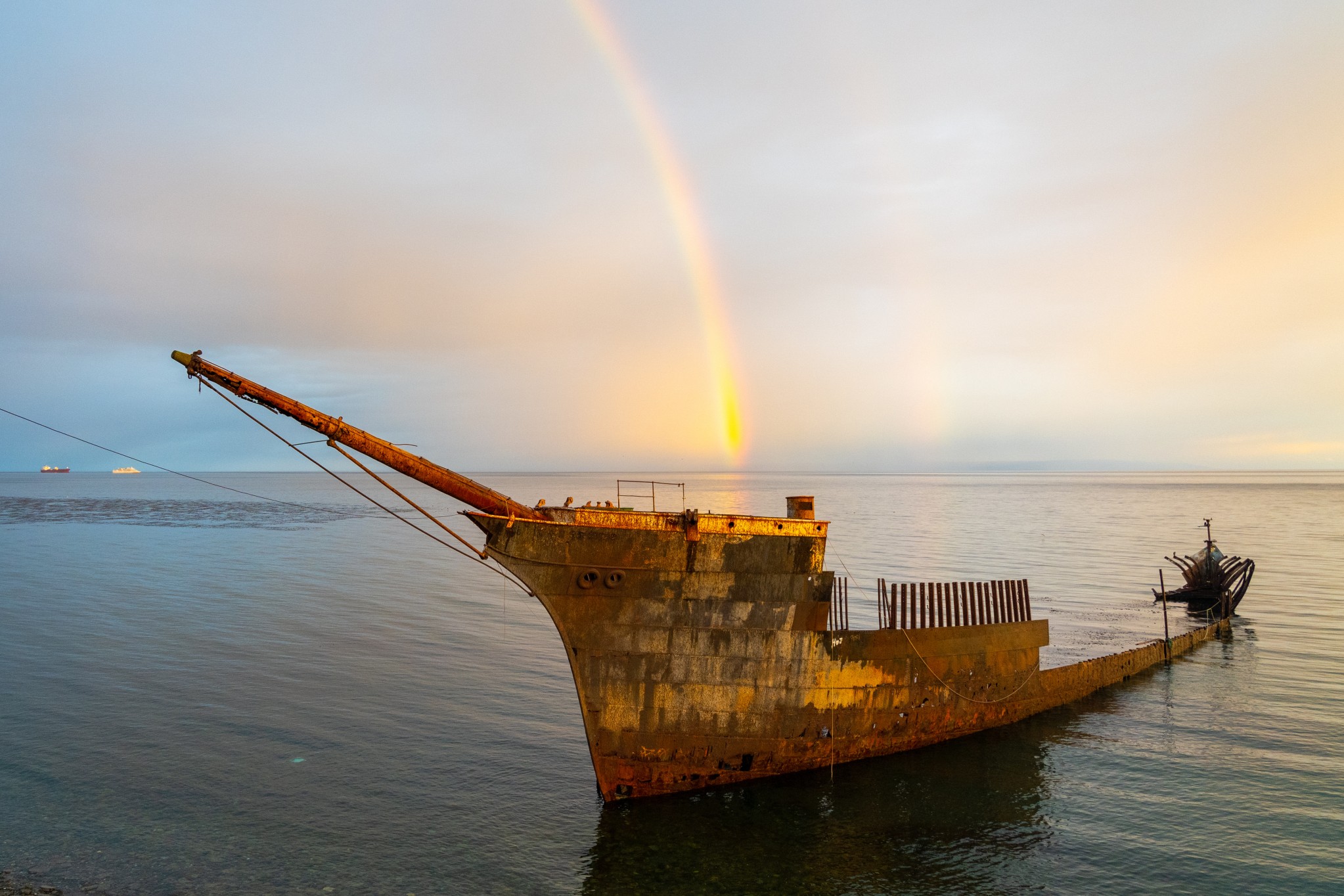 Lord Lonsdale shipwreck with rainbow at dusk in the coast of Punta Arenas, Chile. The Lord Lonsdale started its final journey in Hamburg, Germany in 1909, why it ended up here is a mystery.
