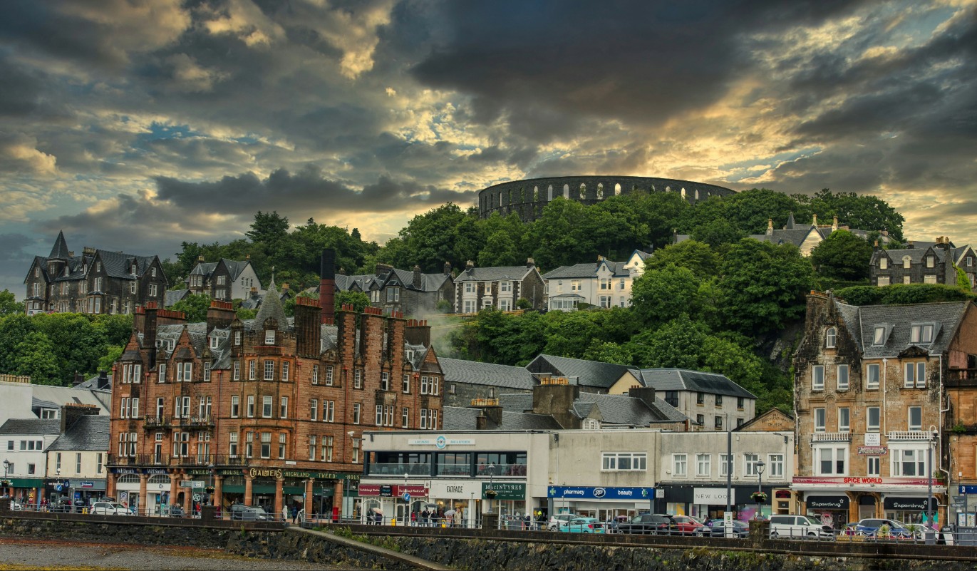 Oban Scotland harbor under dramatic cloudy skies showcasing a European coastal town in the rain