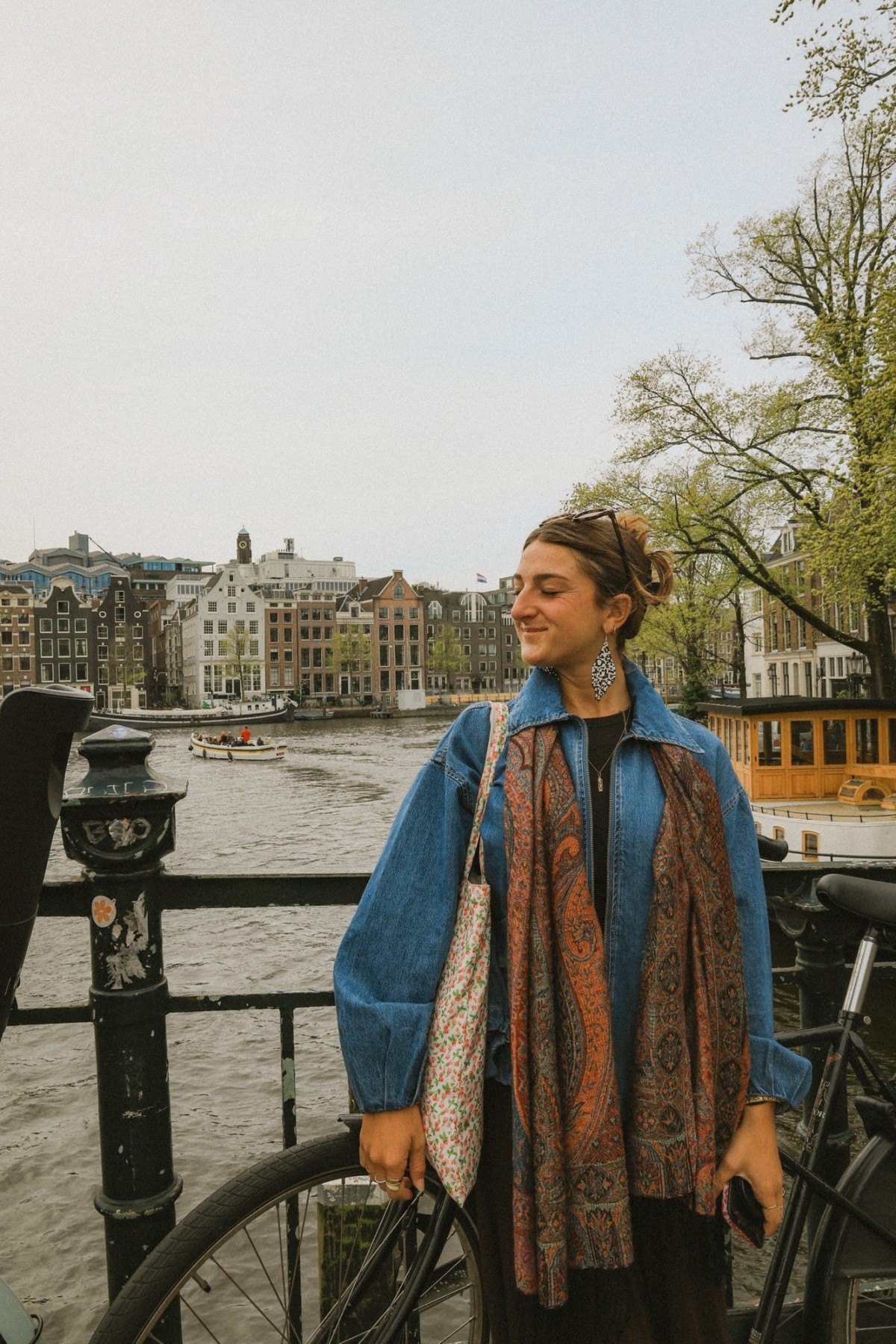 Traveler standing beside an Amsterdam canal reflecting on language and cultural experiences while traveling