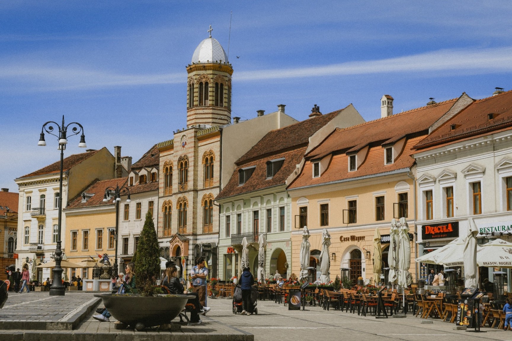 Council Square in Brașov Romania with historic buildings and outdoor cafés in Transylvania