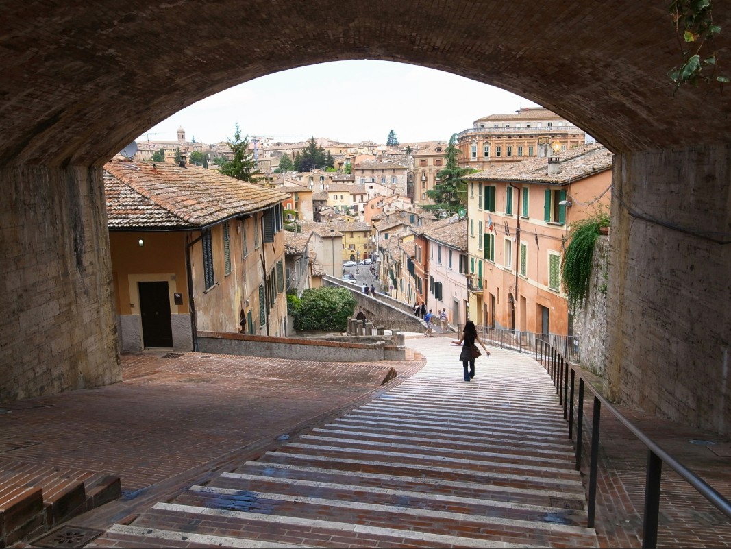 Historic streets and stairway in Perugia Italy framed by an ancient stone arch